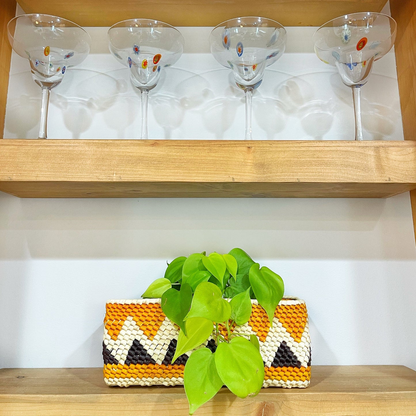 Rectangular handwoven box with a natural tan exterior and a brown and green geometric patterned interior, made from tucuma palm fibers.