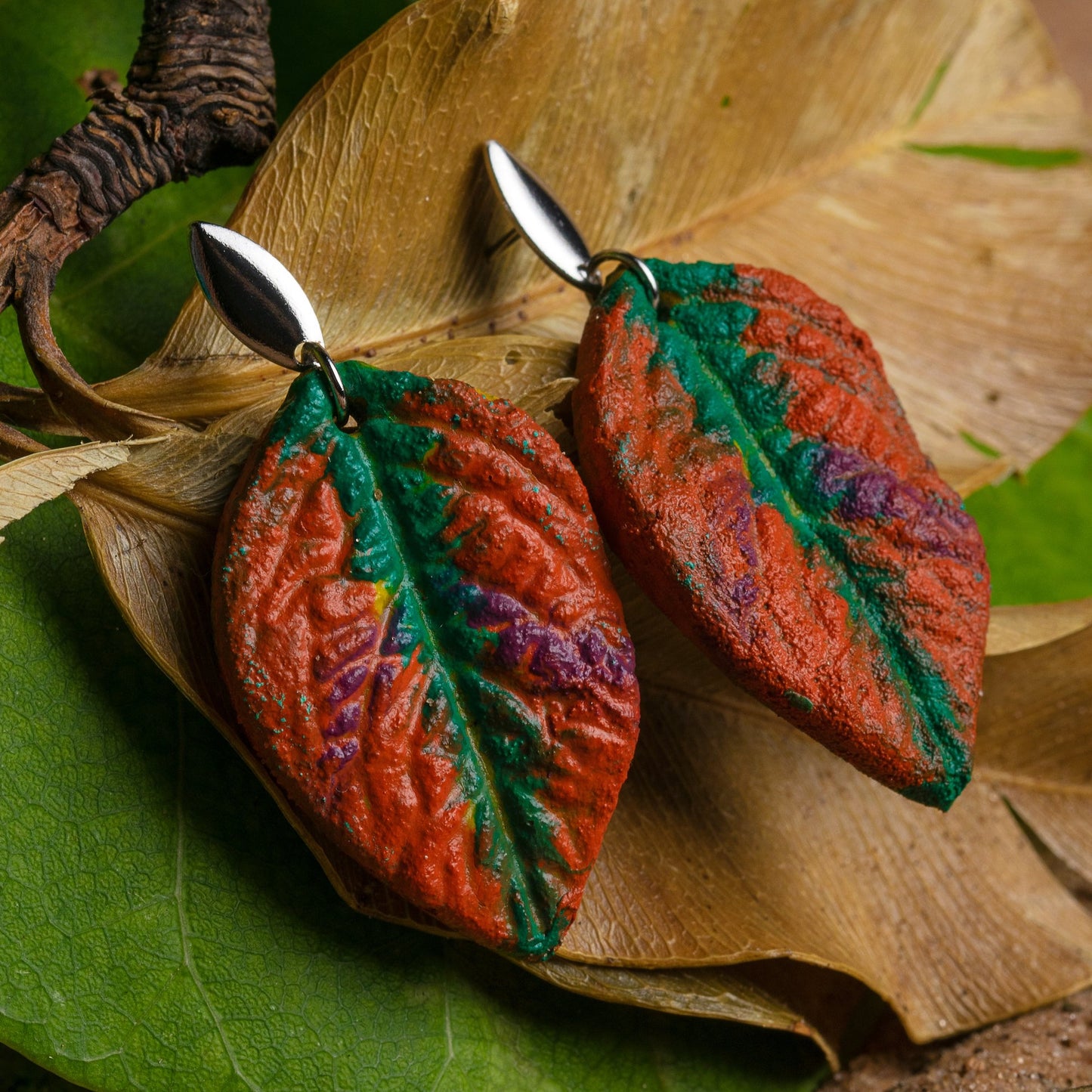Leaf-shaped earrings handcrafted from natural rubber (light brown) blended with açaí seed fiber (dark brown flecks), featuring a matte finish and subtle vein details. Nickel-free.