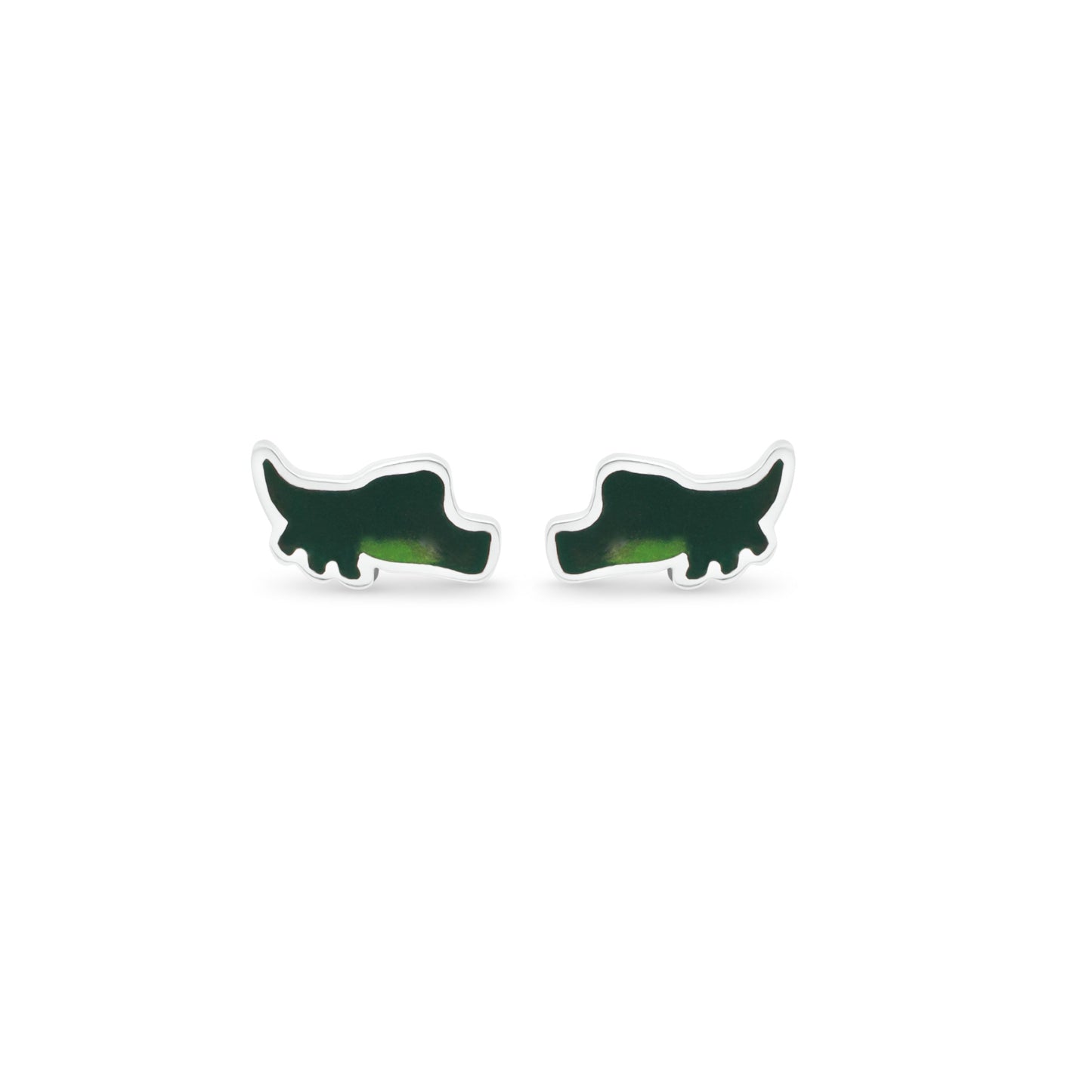 A pair of silver alligator silhouette earrings rests on a crisp white background. The two shades of green on the earrings create a realistic depiction of the reptile, with its body in profile and tail curving gracefully to the right.