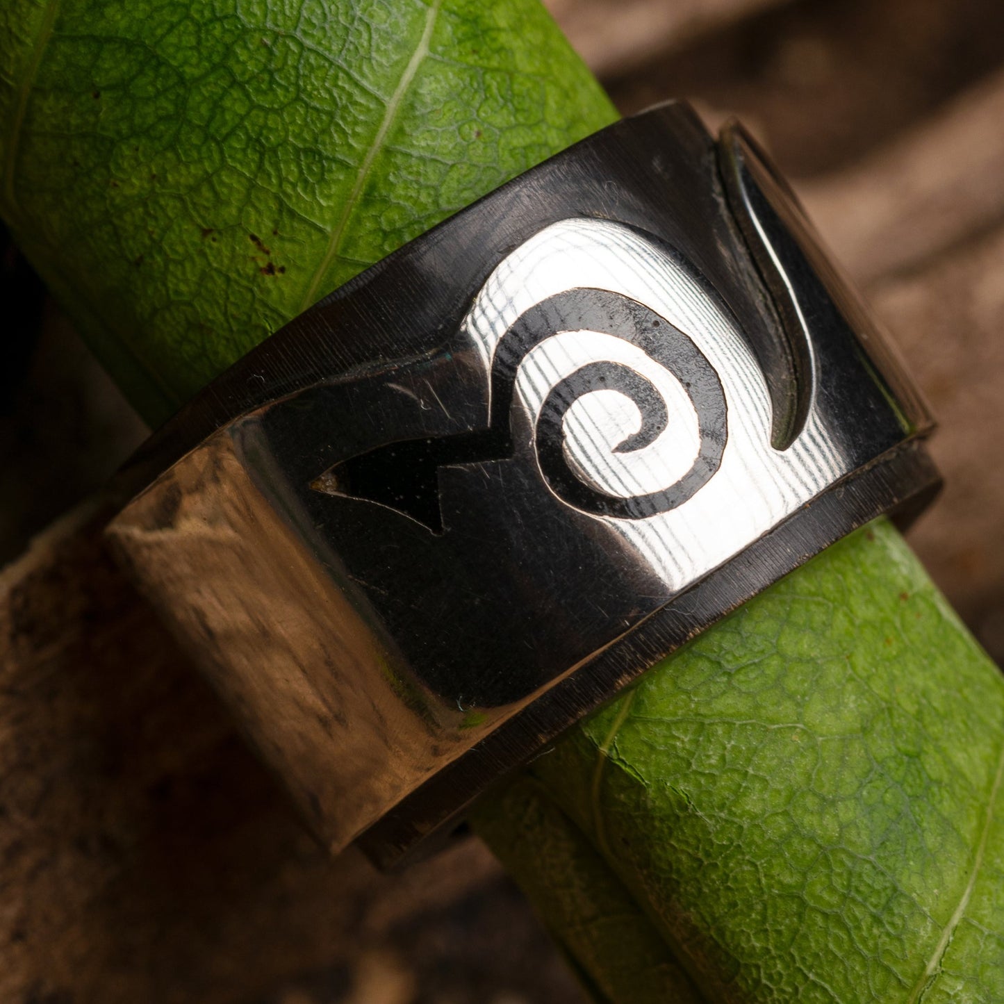 Sterling silver ring featuring an inlay made from a repurposed buffalo horn fragment. The ring also incorporates a Marajoara symbol, a design linked to the Amazon's cultural heritage.