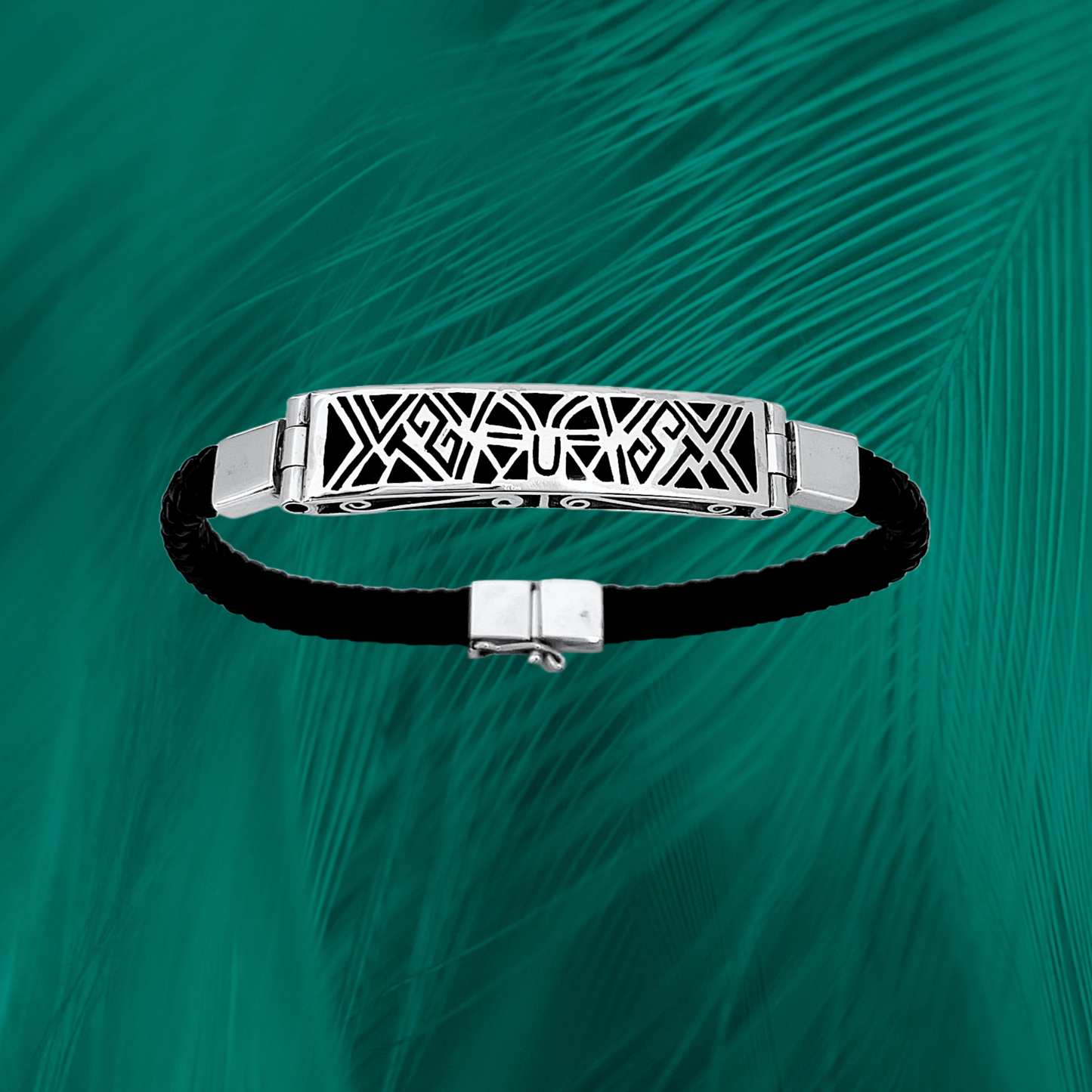 sterling silver bracelet with an elegant tribal inlay design on a black vegan leather strap, set against a vibrant green feathered texture.