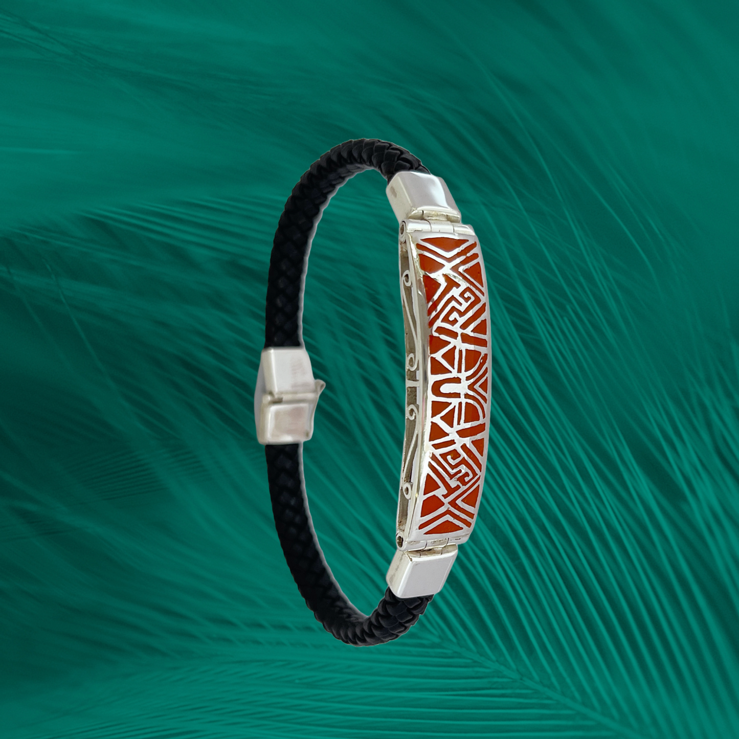 An exquisite 950 sterling silver bracelet features a bold red inlay with a tribal design, contrasted against a dark, braided vegan leather strap.