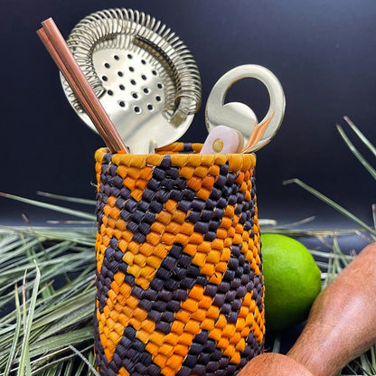 Handwoven utensil holder in vibrant orange and black, filled with kitchen tools, to showcase the versatility.