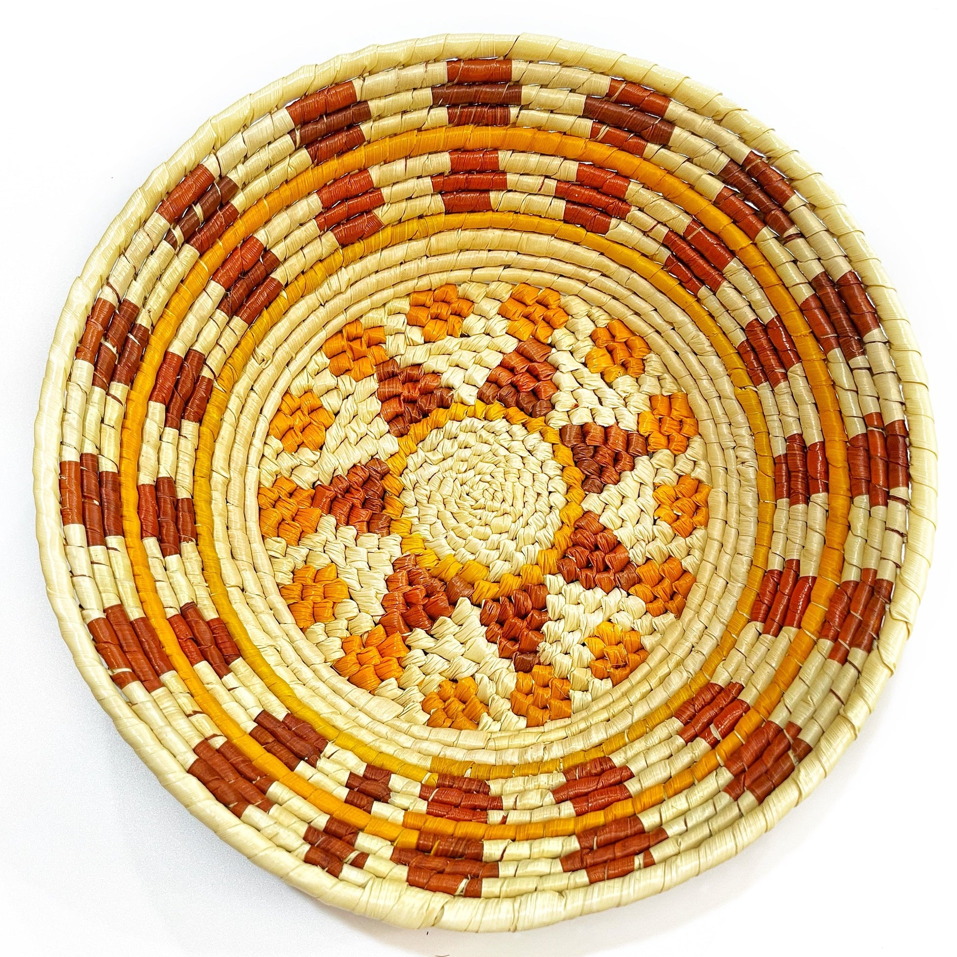 Circular tucuma bowl with beige background, radiating orange and brown patterns, and concentric design.