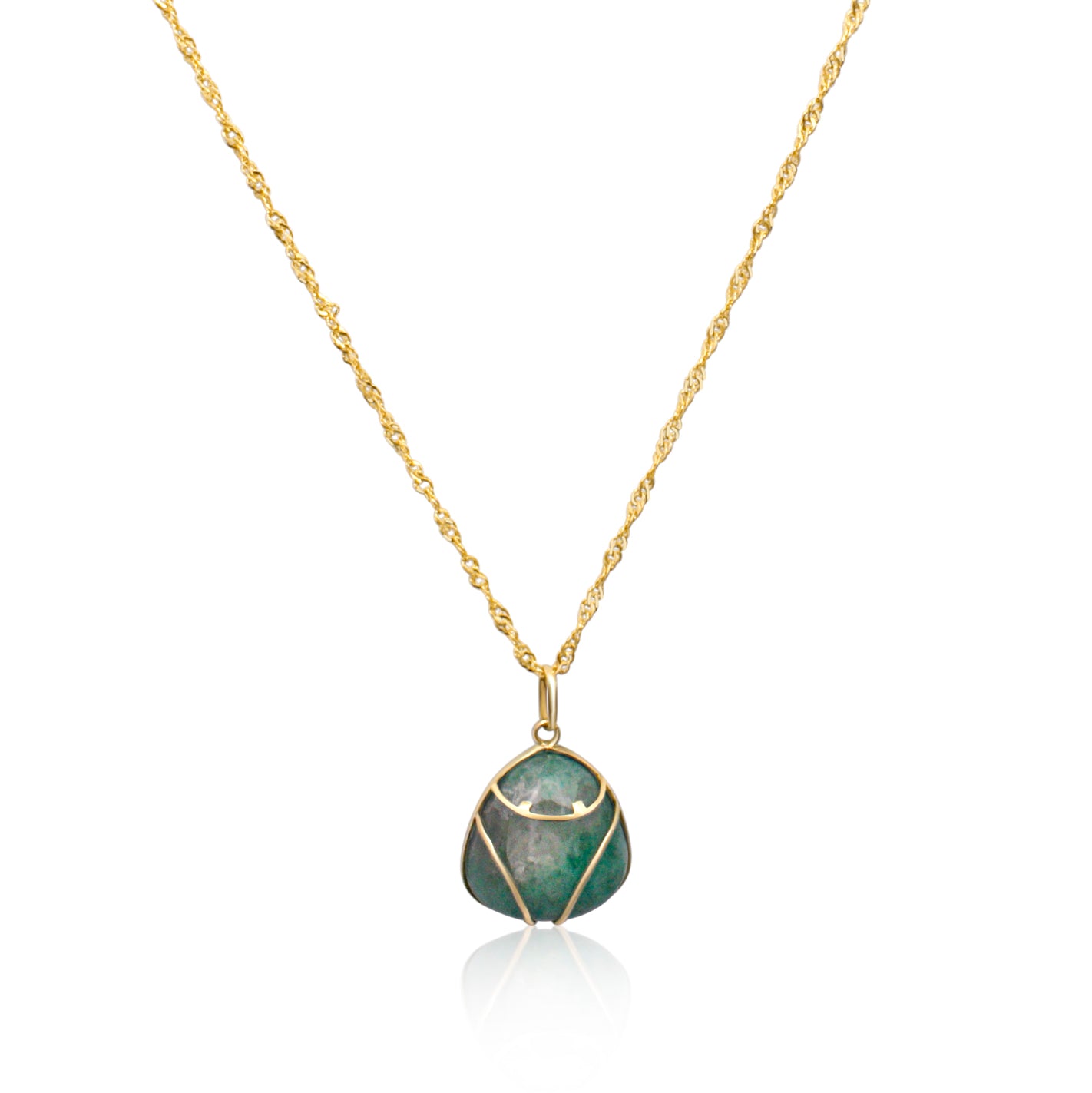 The necklace is an 18k gold Muiraquitã-inspired piece with a pendant featuring a rich green emerald. The gold is crafted to outline the shape of a frog, intertwined with the gemstone.