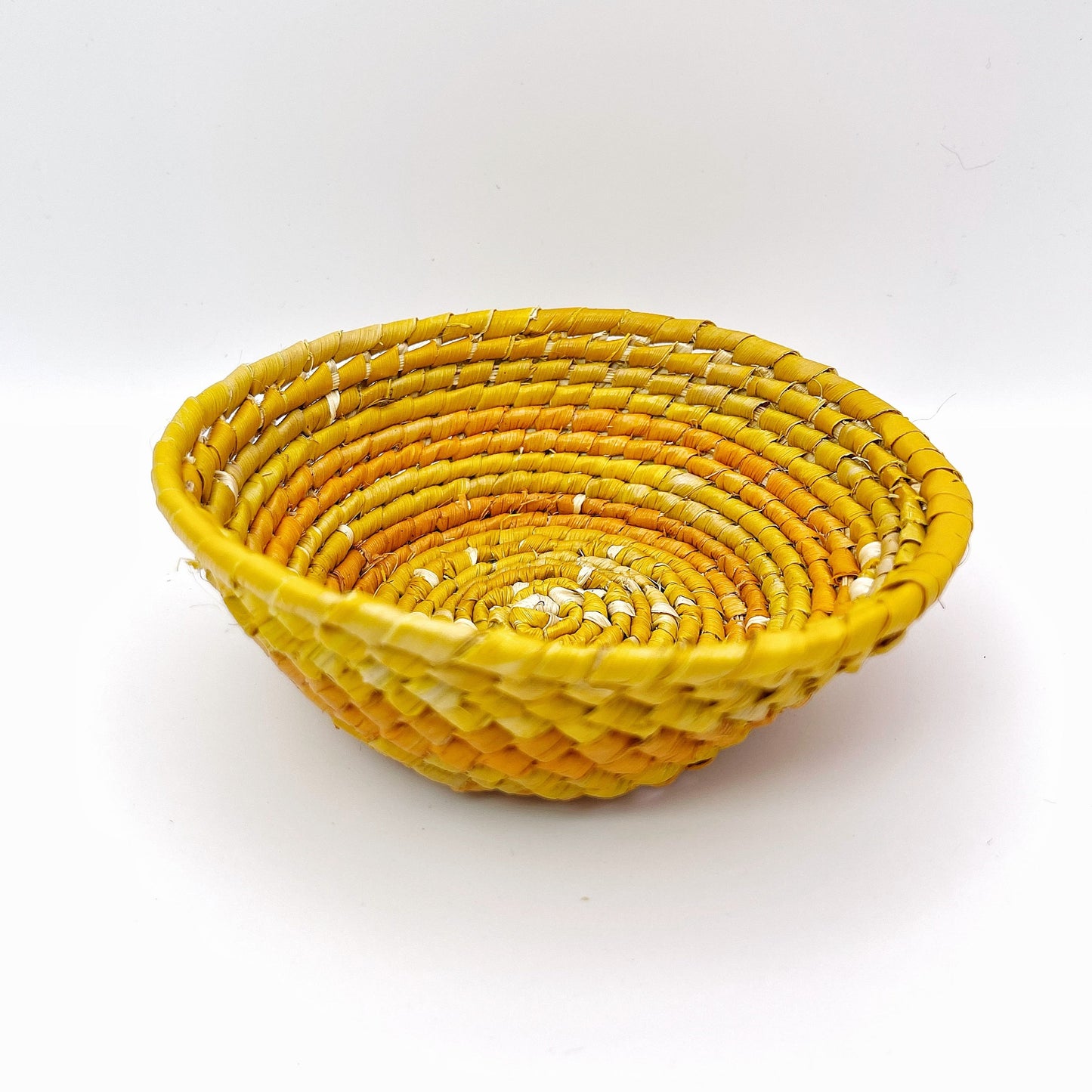 Handwoven bowl: vibrant yellow & orange spiral pattern. White stitching accents coils for a sunburst effect.