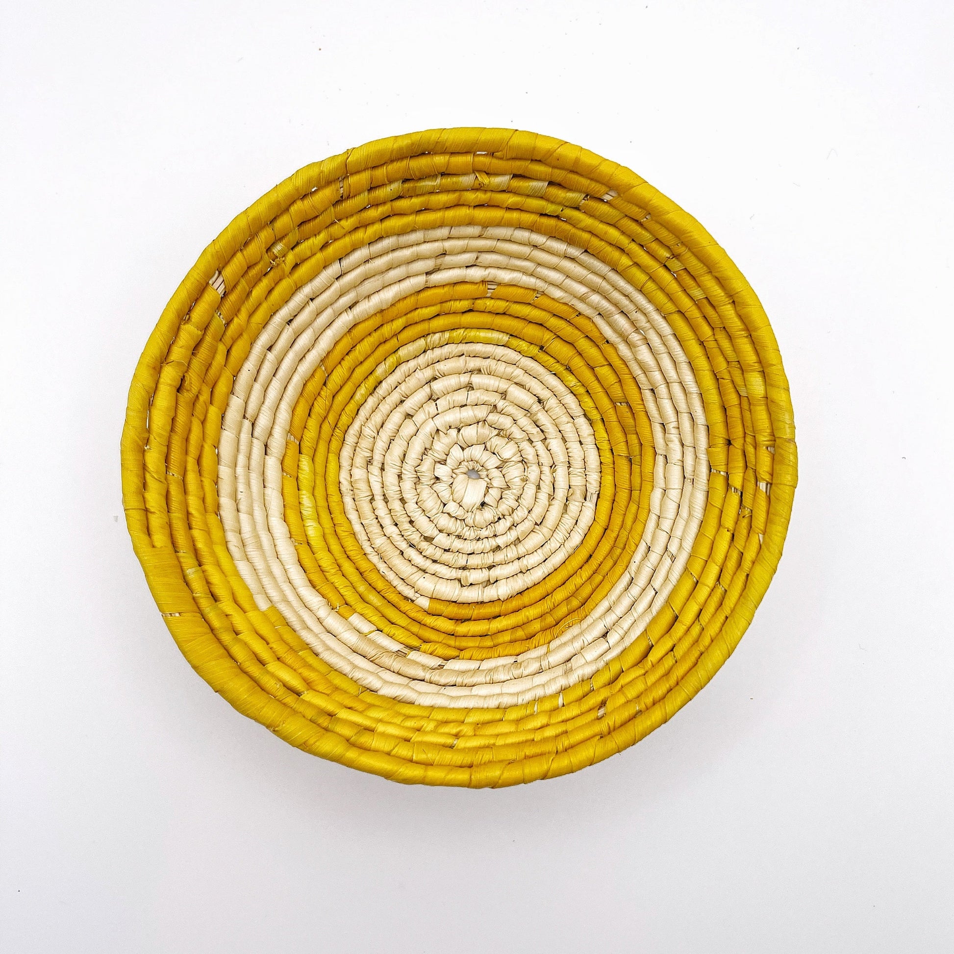 Handwoven Amazonian trinket bowl. Natural beige tucuma palm fibers with a yellow and cream geometric. Perfect for storing small items like jewelry or keys.