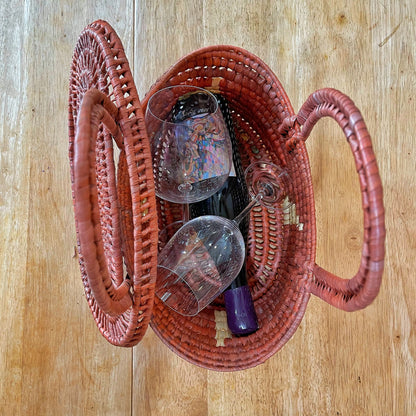 Brown Handwoven Tucuma fiber baskets from Brazil. Spacious interior holds a bottle of wine and two wine glasses.