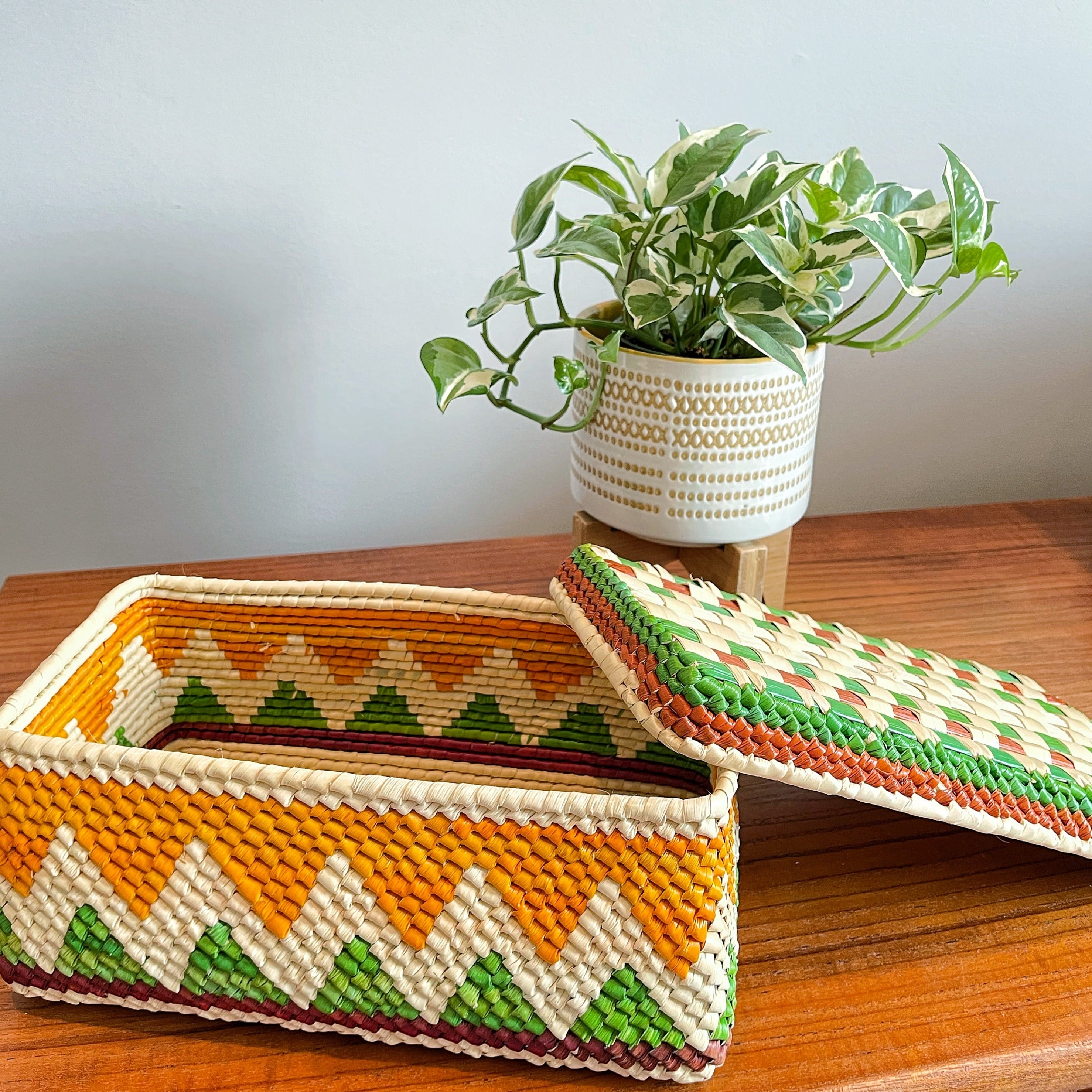 Tucumã palm straw, a natural and sustainable material with a golden or brown color.Rectangular with a flat bottom, The box has a lid .