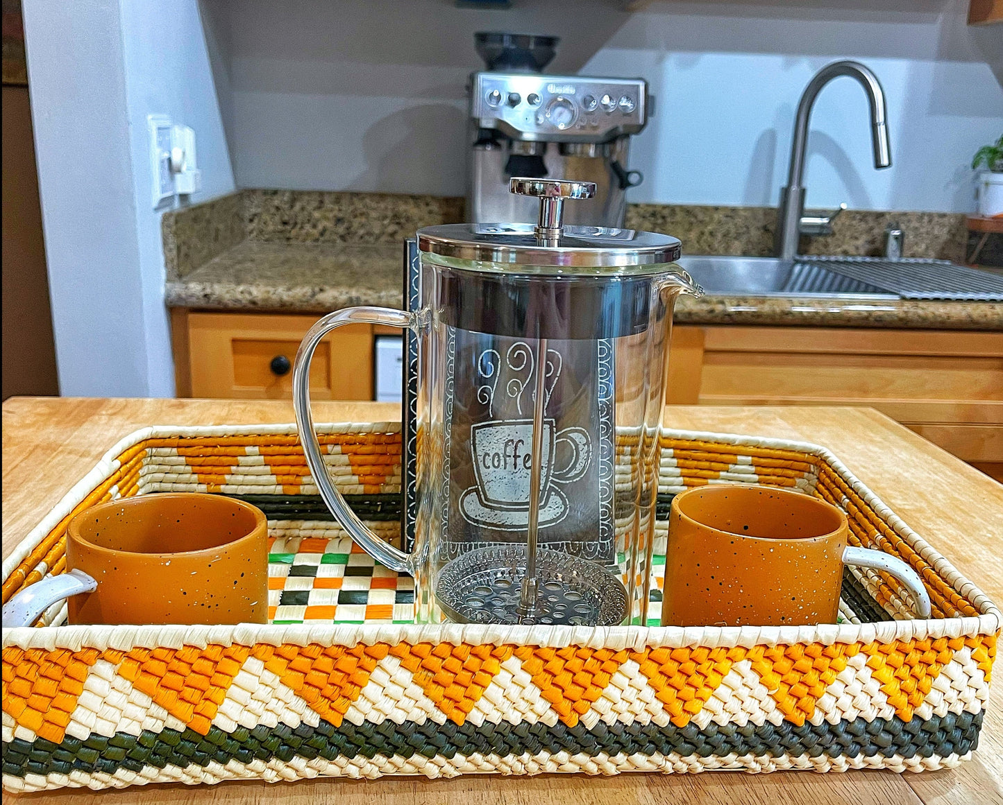 Handwoven Amazonian tray: geometric pattern in white, orange shades, green & black. Diagonal check, vibrant & organic.