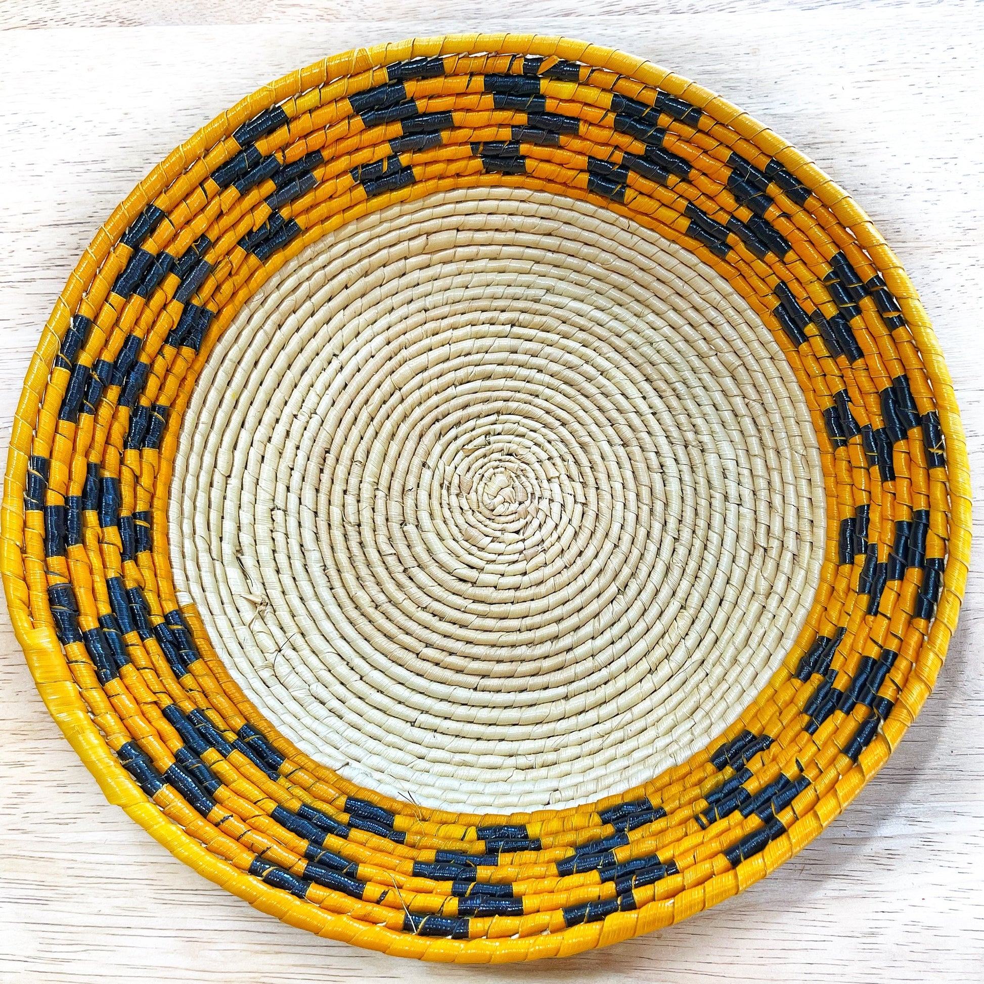 bowl with a natural beige spiral and a yellow rim, interspersed with black geometric accents.