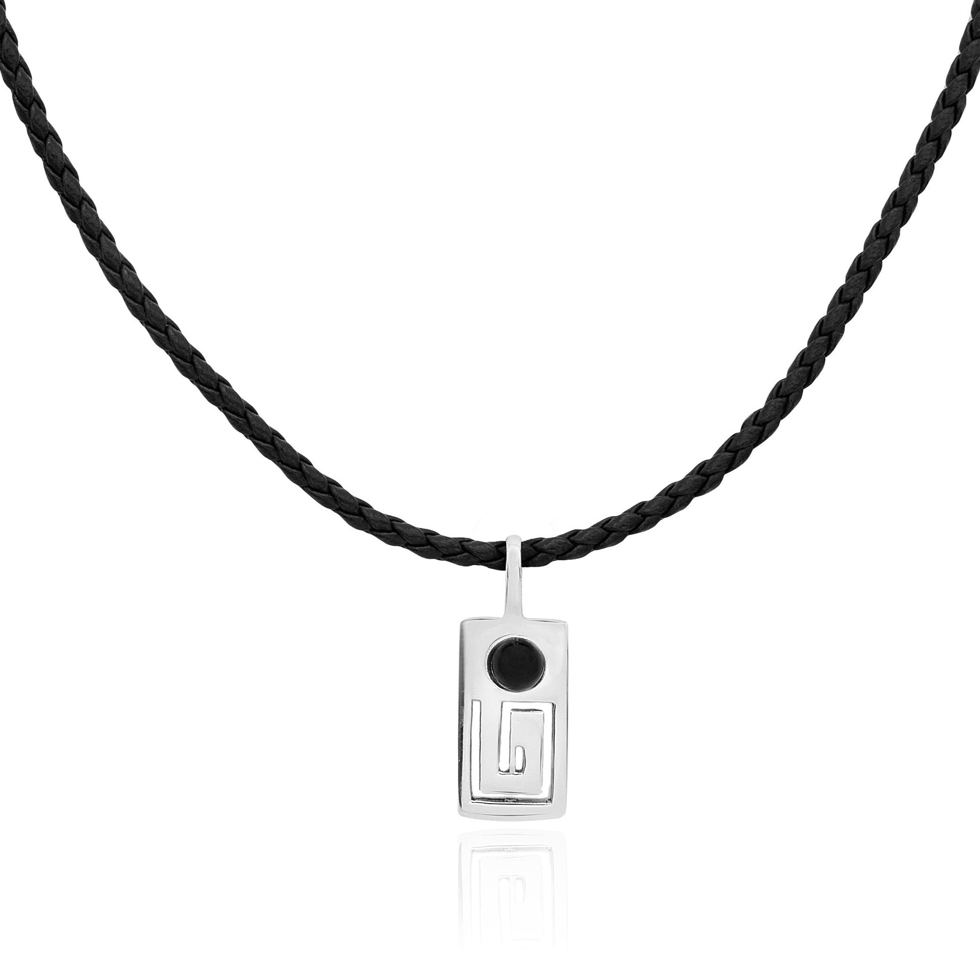 A sterling silver Marajoara necklace featuring a rectangular pendant with a black onyx gemstone on a braided black leather cord, symbolizing protection.