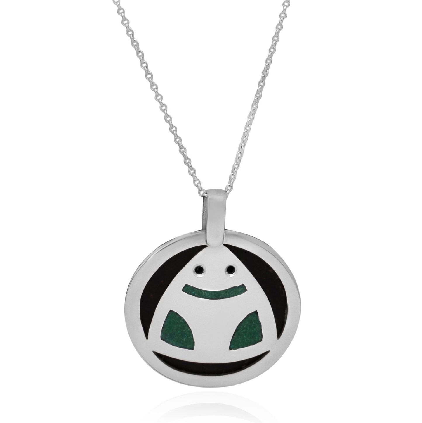 This image displays a circular .925 sterling silver necklace featuring a stylized Muiraquitã frog pendant. Made with coconut shell and green inlay, the pendant embodies Amazonian cultural motifs and the essence of nature.