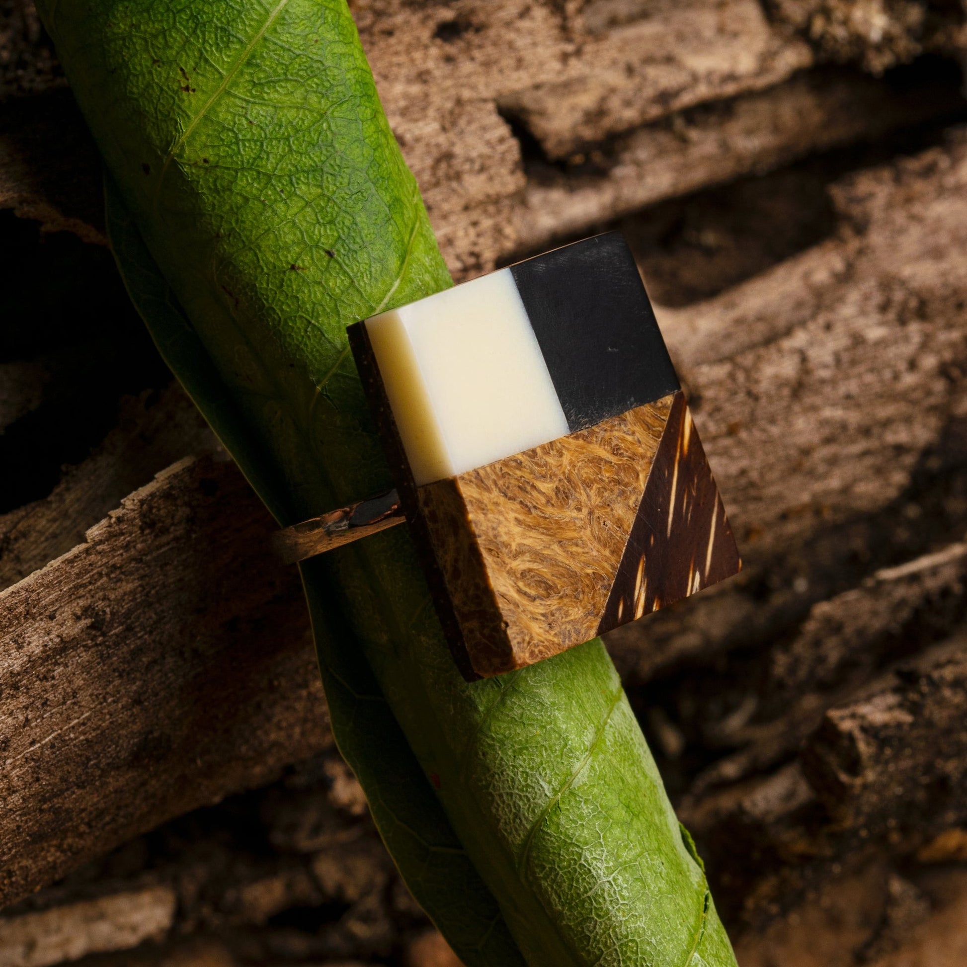 sterling silver ring featuring a geometric seed marquetry inlay. The inlay appears to incorporate babassu, bone, horn, and peach palm