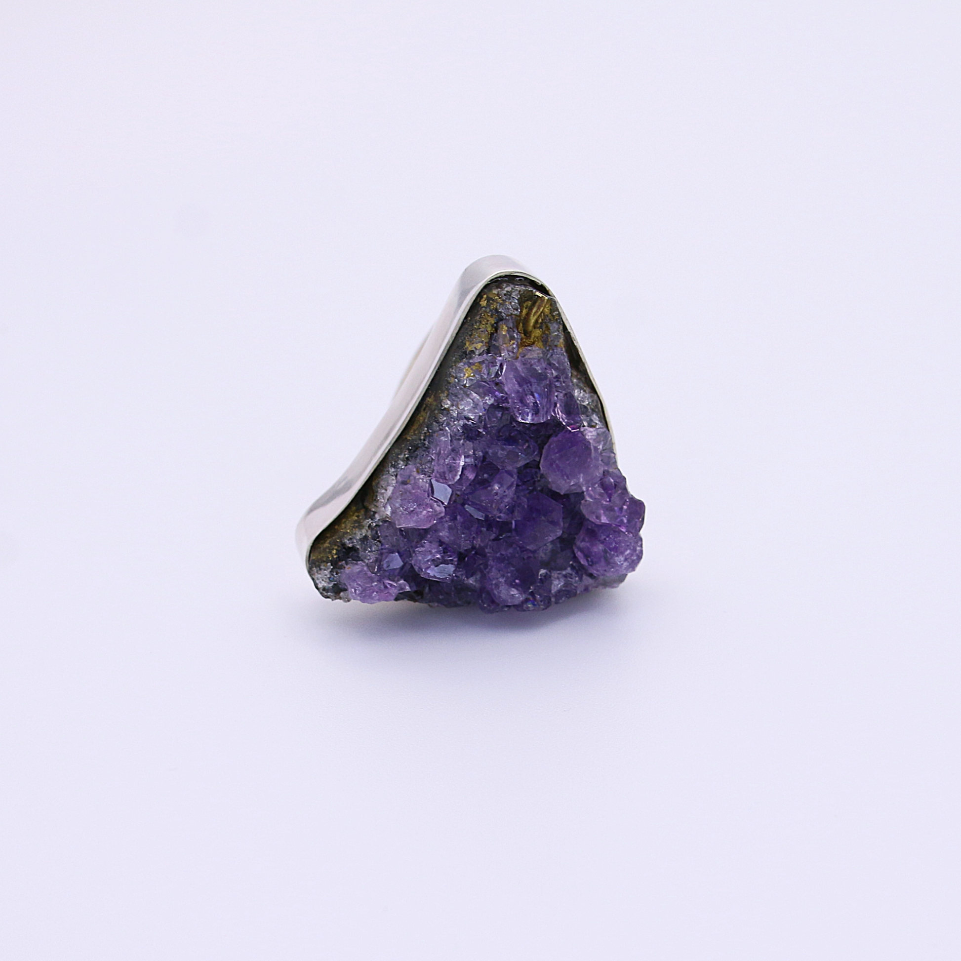 A captivating raw amethyst ring, showcasing its rich purple hues on a clean white background.