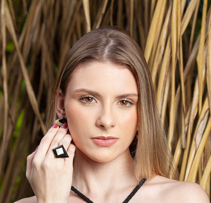 Woman models a striking geometric ring! .925 silver showcases contrasting brown & white buffalo bone & horn inlays. Natural setting & soft makeup highlight the jewelry's boldness.