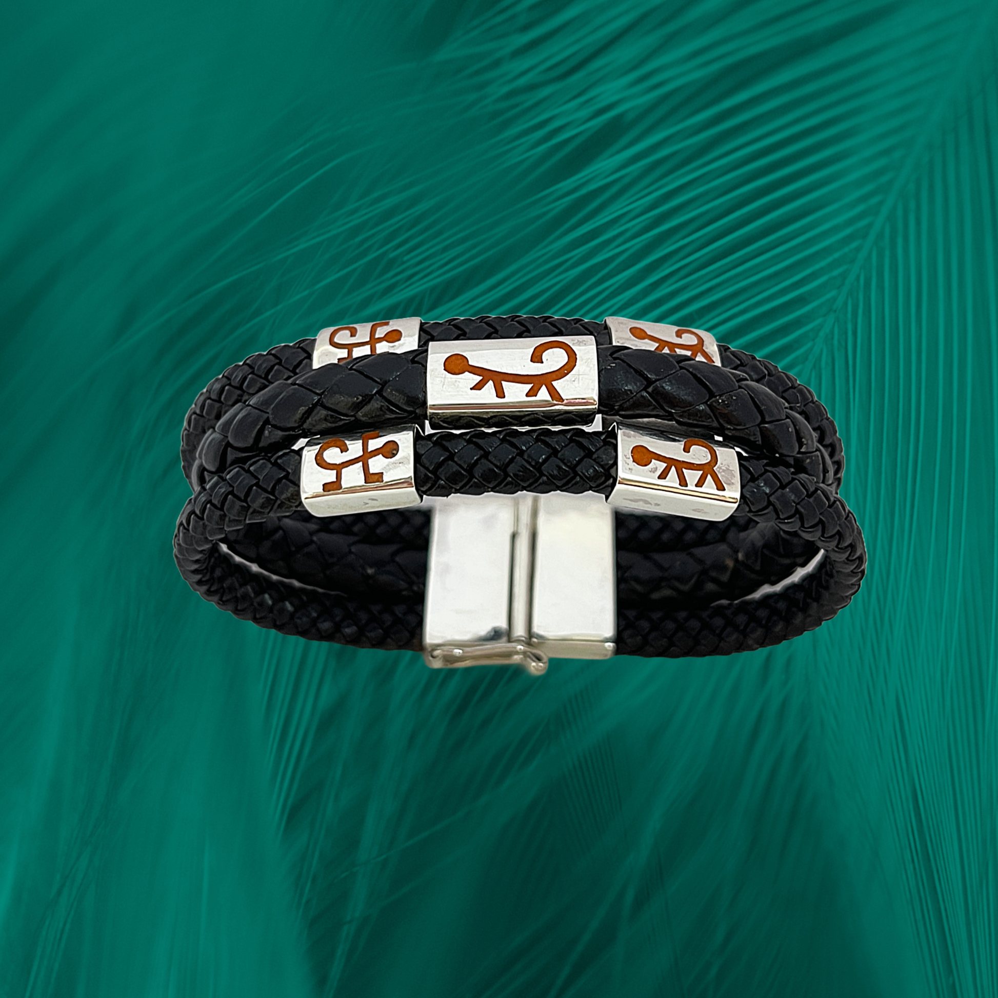 This image features a triple-layered vegan leather bracelet adorned with .925 silver charms that showcase a Marajoara monkey design, invoking the guardians of the Amazon.