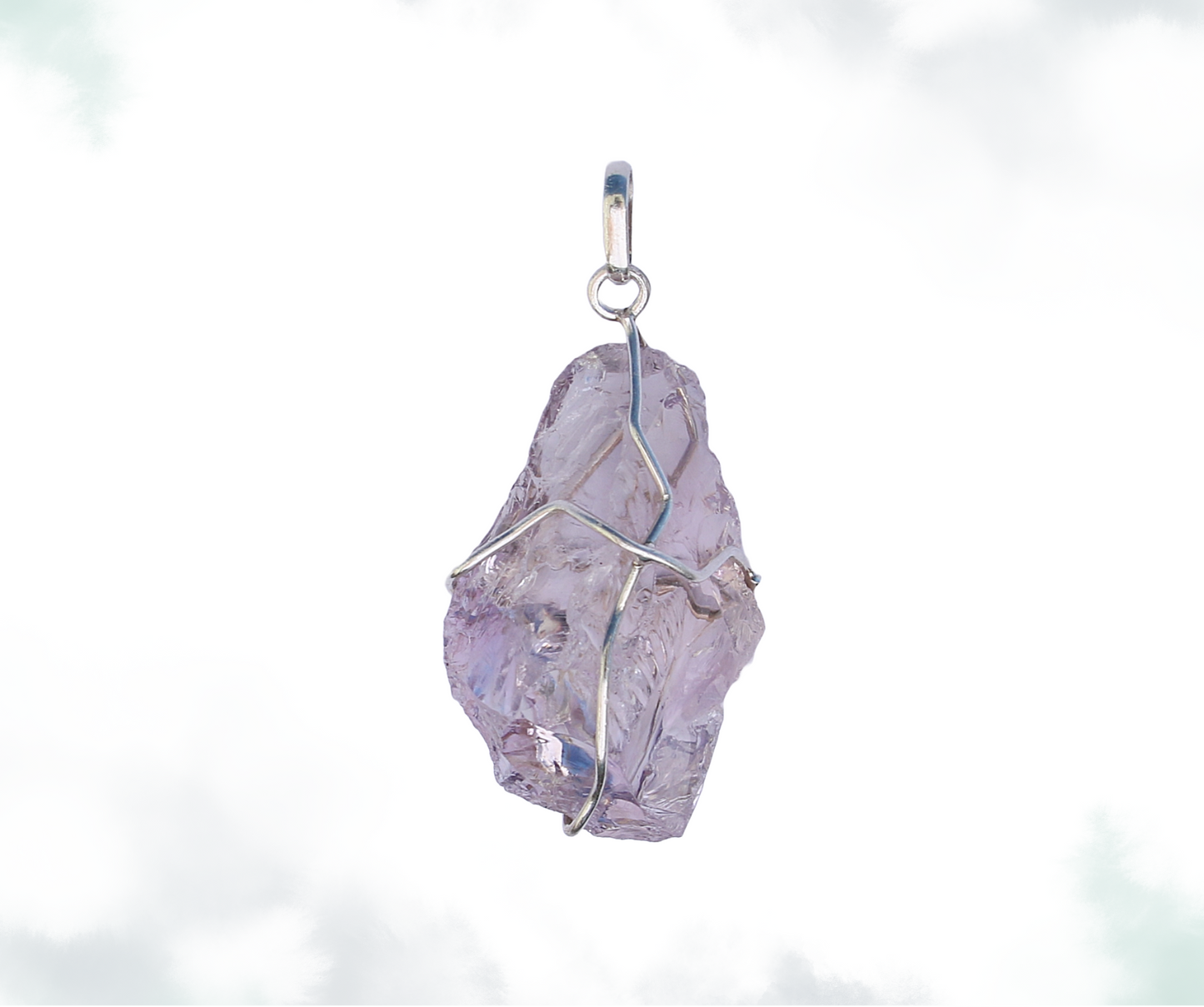 Raw amethyst crystal pendant wrapped in silver wire, with a simple loop on top, against a cloudy sky backdrop.