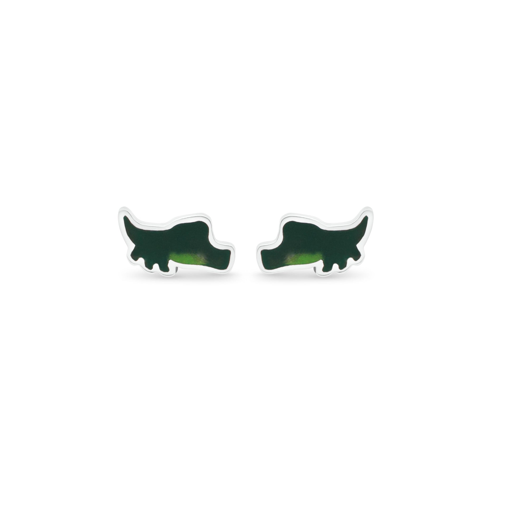 A pair of silver alligator silhouette earrings rests on a crisp white background. The two shades of green on the earrings create a realistic depiction of the reptile, with its body in profile and tail curving gracefully to the right. 