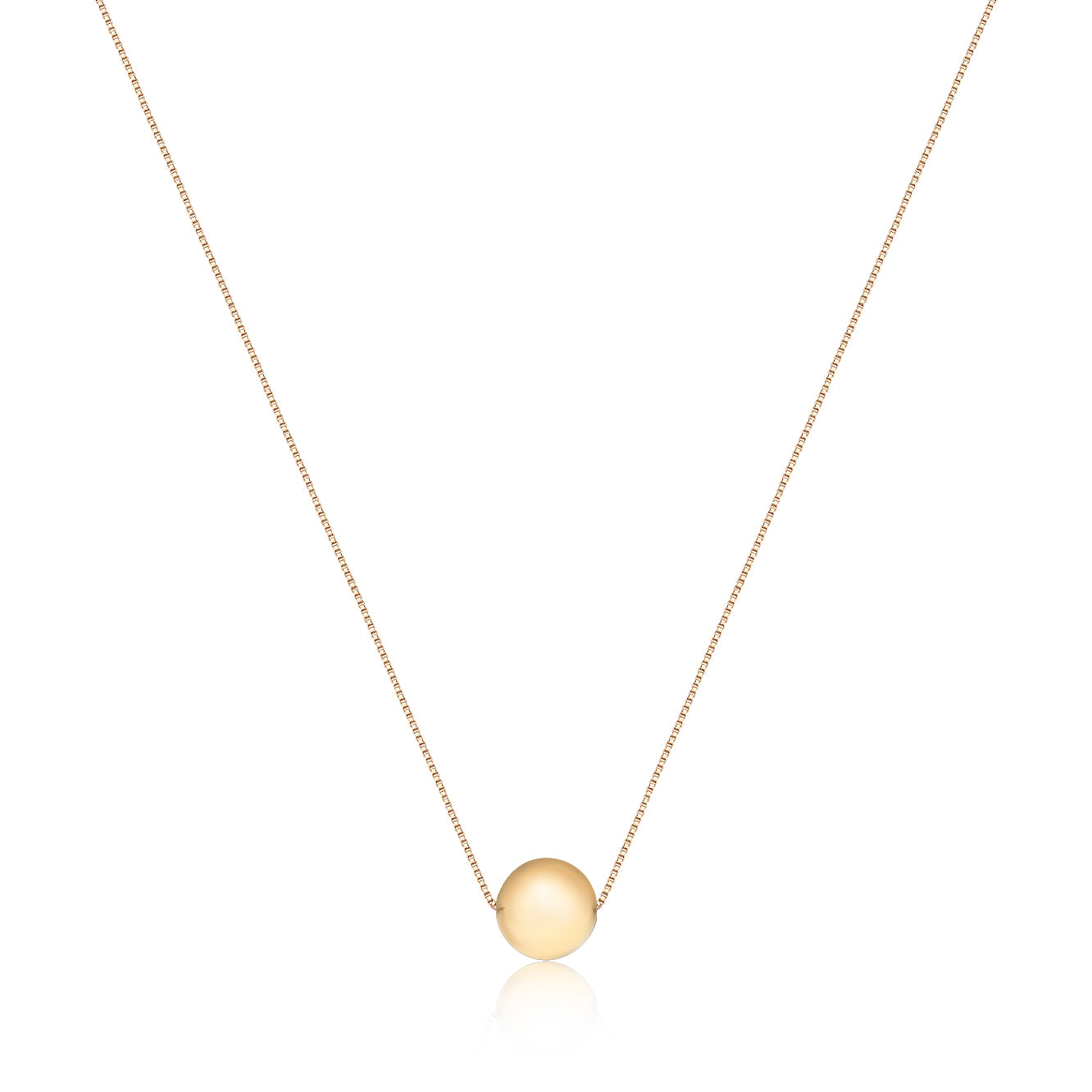 A delicate gold chain holds a polished, round gold pendant, embodying timeless sophistication and completeness.