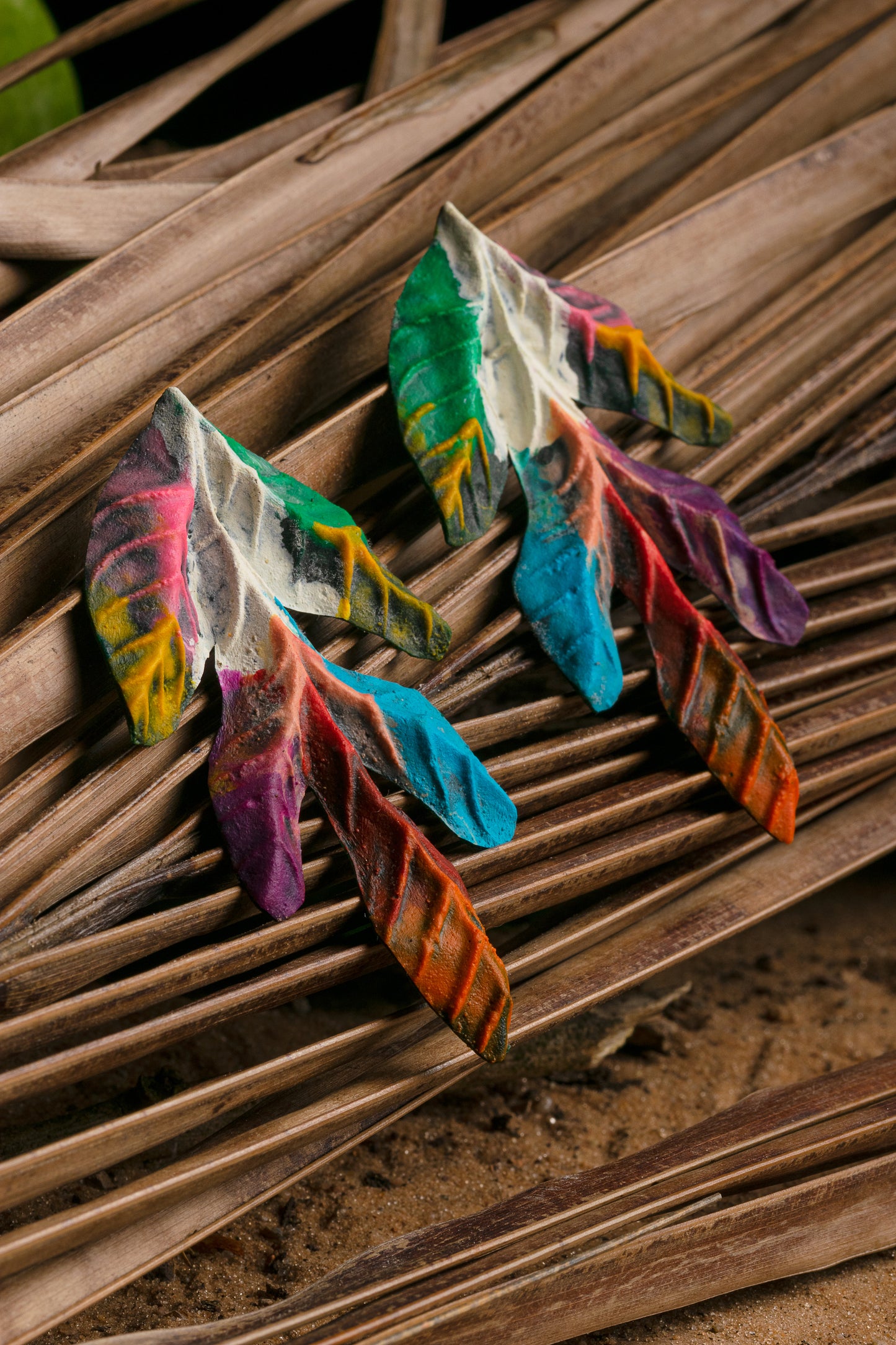 Vibrant leaf earrings on a fiber mat! Sustainably crafted from Amazonian latex and açaí, showcasing a natural vein pattern. Artisan-made beauty.