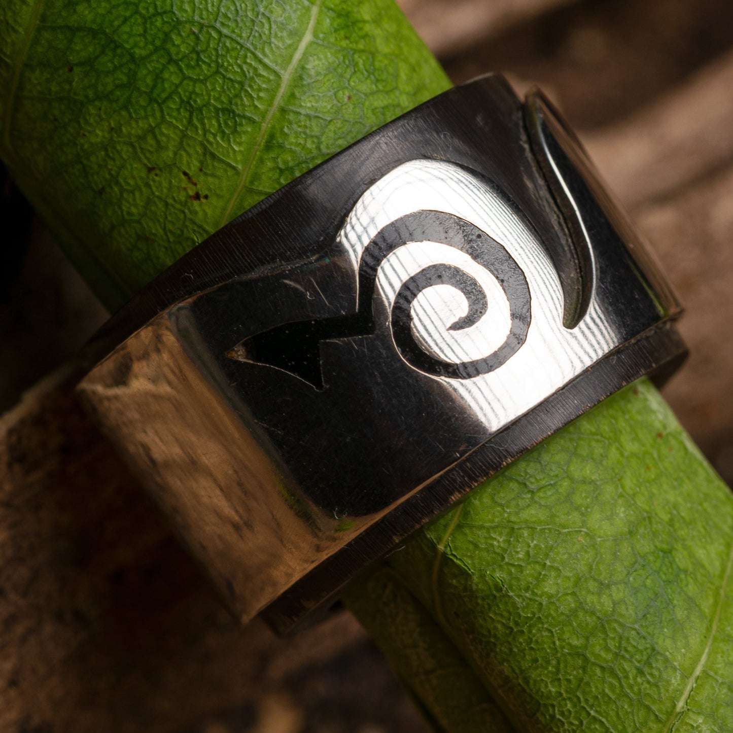 Sterling silver ring featuring an inlay made from a repurposed buffalo horn fragment. The ring also incorporates a Marajoara symbol, a design linked to the Amazon's cultural heritage. 