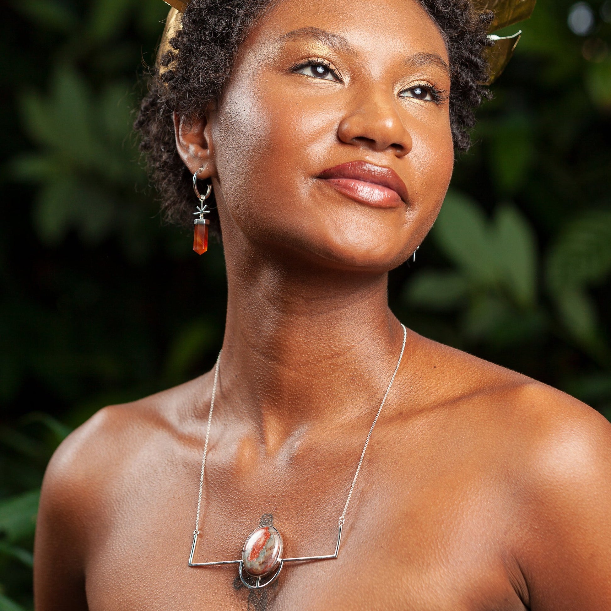 A model showcases a sterling silver necklace with a crazy lace agate pendant and agate gemstone earrings.