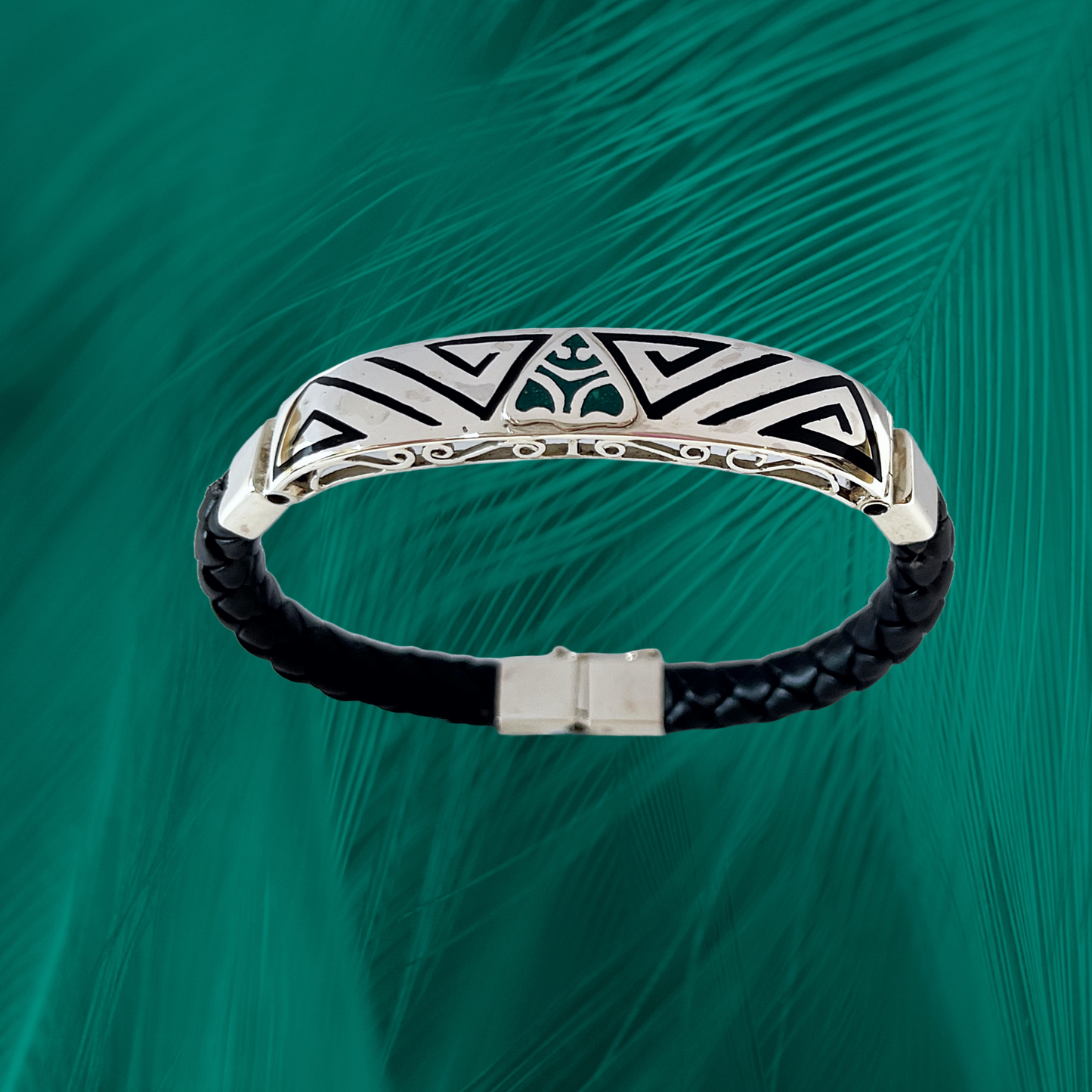 Sterling silver Muiraquita Magic bracelet on a black vegan leather strap. The bracelet features a detailed etching of a Muiraquita creature, a mythical Amazonian shapeshifter.