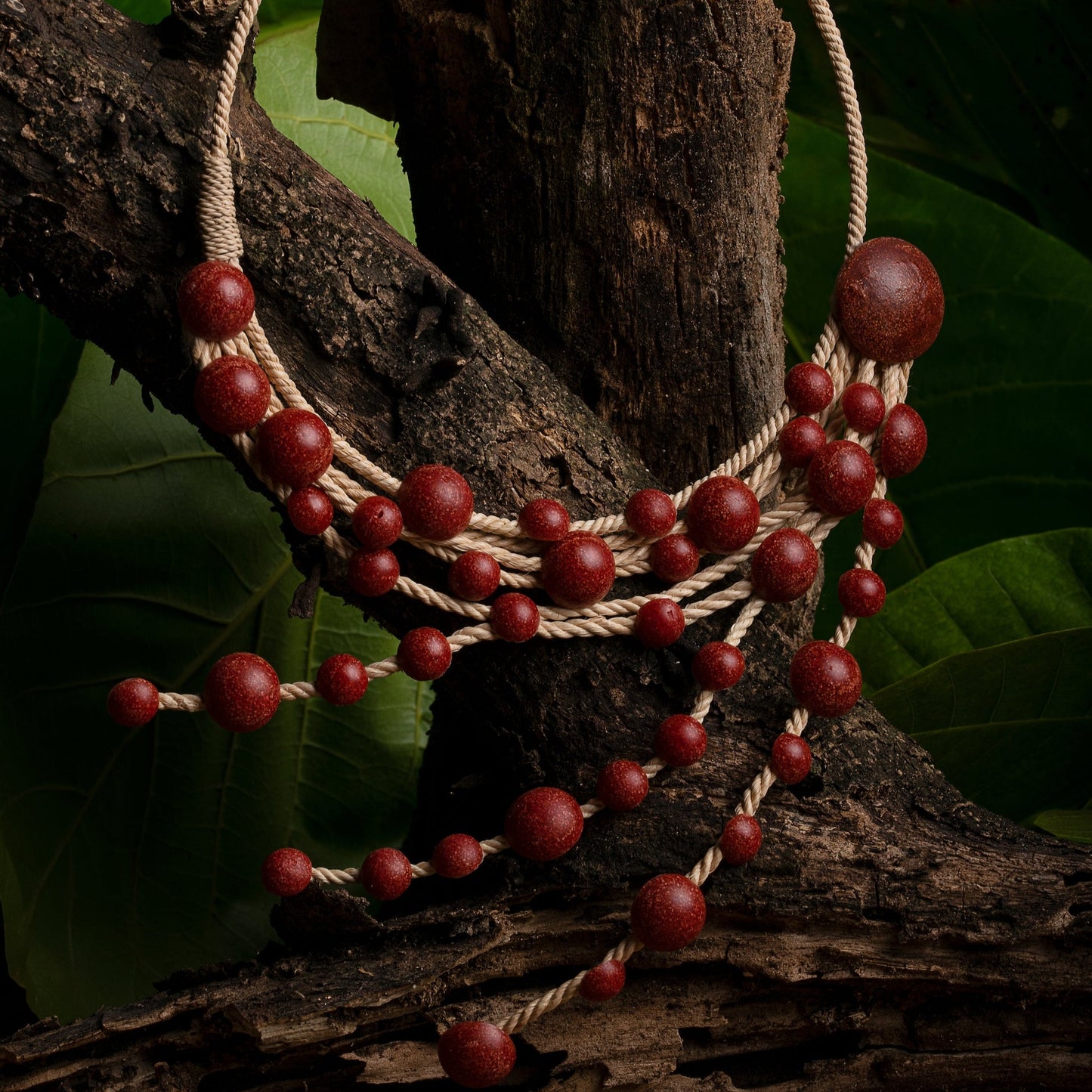 Handcrafted necklace with Açaí seeds and Buriti fiber on natural backdrop