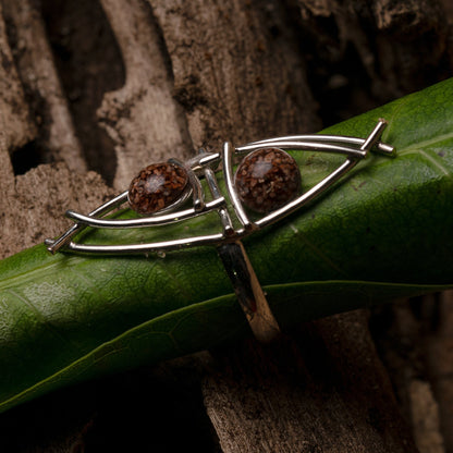 The Water Mirror ring in sterling silver, with açaí seeds and resin, reflects the intricate beauty of Amazonian craftsmanship.